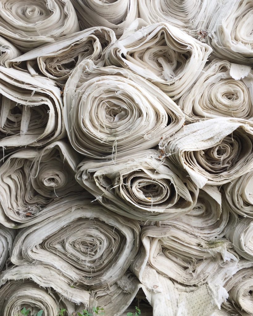 Fabric rolls in different shades of white. Those organic fabrics are made of renewable sources or recycled materials.